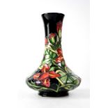 MOORCROFT; a baluster vase of cylinder form with black ground and tube lined floral decoration,