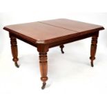 A Victorian mahogany wind-out dining table with one extra leaf, with canted corners and on turned
