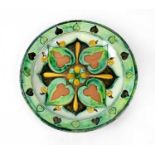 DELLA ROBBIA; an early 20th century plate, with green and brown ground and abstract leaf decoration,