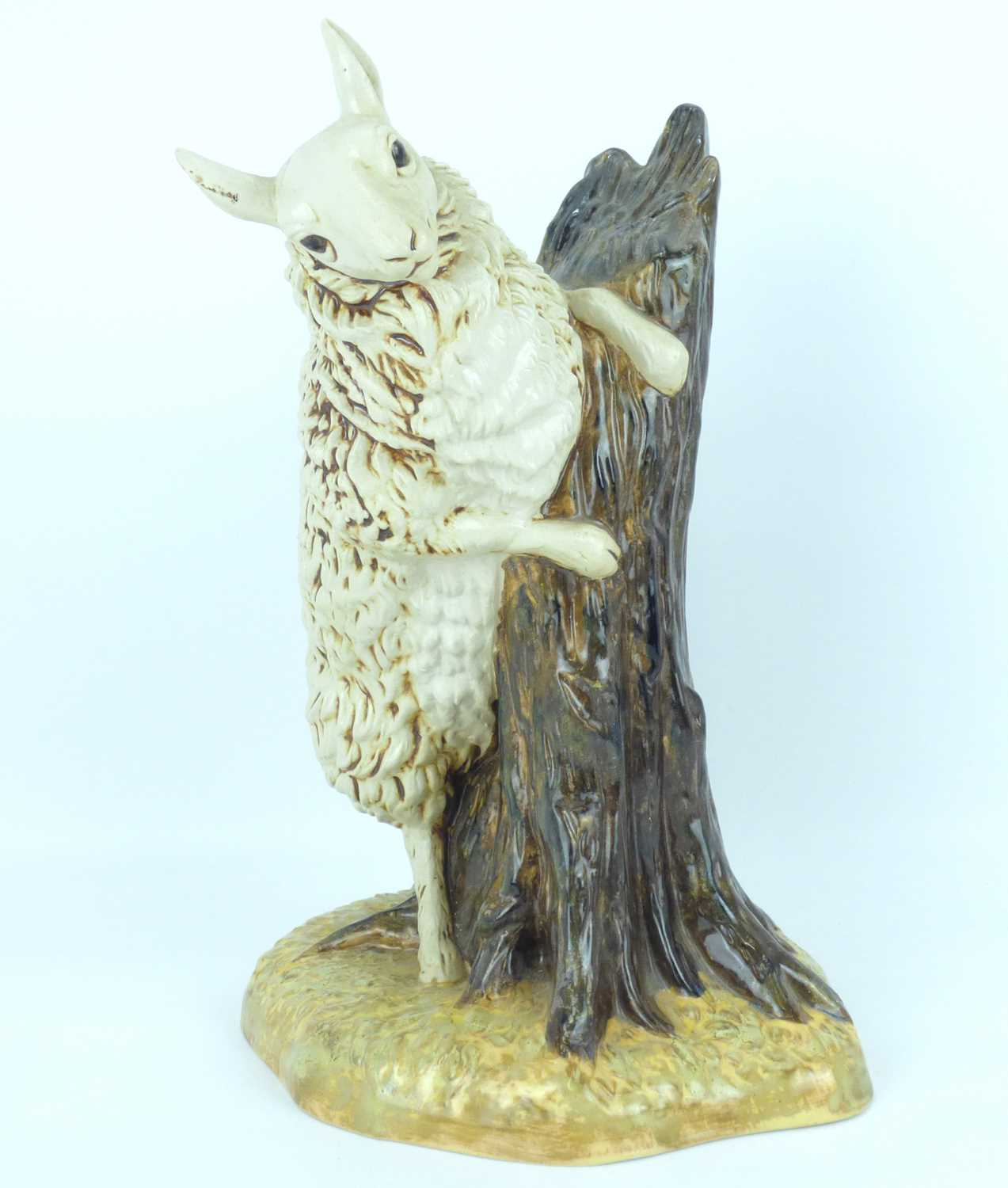 COBRIDGE POTTERY; a 'Bo Peep Sheep' pottery figure depicting a ewe on a tree stump, designed by