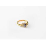 An 18ct gold ring set with sapphire and fourteen diamonds, stamped 750, size O, approx. 3.6g.