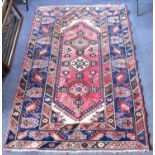 An early 20th century Turkish rug with central lozenge of three guls on a red ground, within three