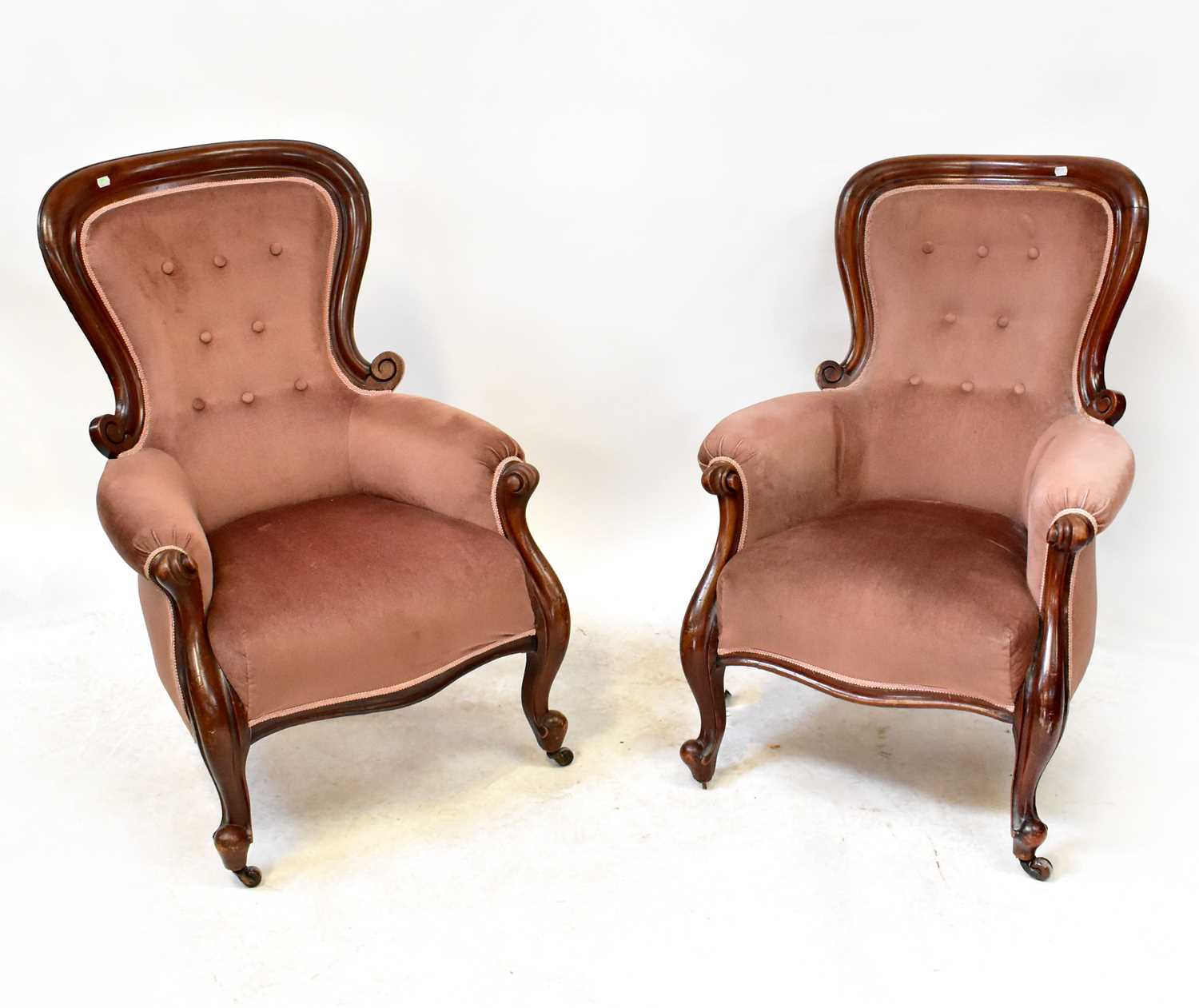 A pair of Victorian mahogany framed balloon back parlour elbow chairs with scrolling arms, shaped