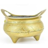 A 20th century Chinese brass censer with upright oval cut-out handles, the body decorated with