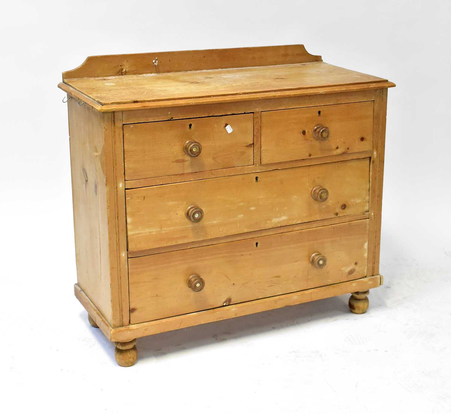 An early 20th century pine chest of two short over two long drawers, raised on bun feet, 93 x 103