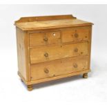 An early 20th century pine chest of two short over two long drawers, raised on bun feet, 93 x 103