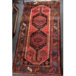 An Afghan rug with central lozenge and two geometric patterns, floral design to the corners, on a