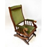 A stained beech American rocking chair with studded green velour upholstery.