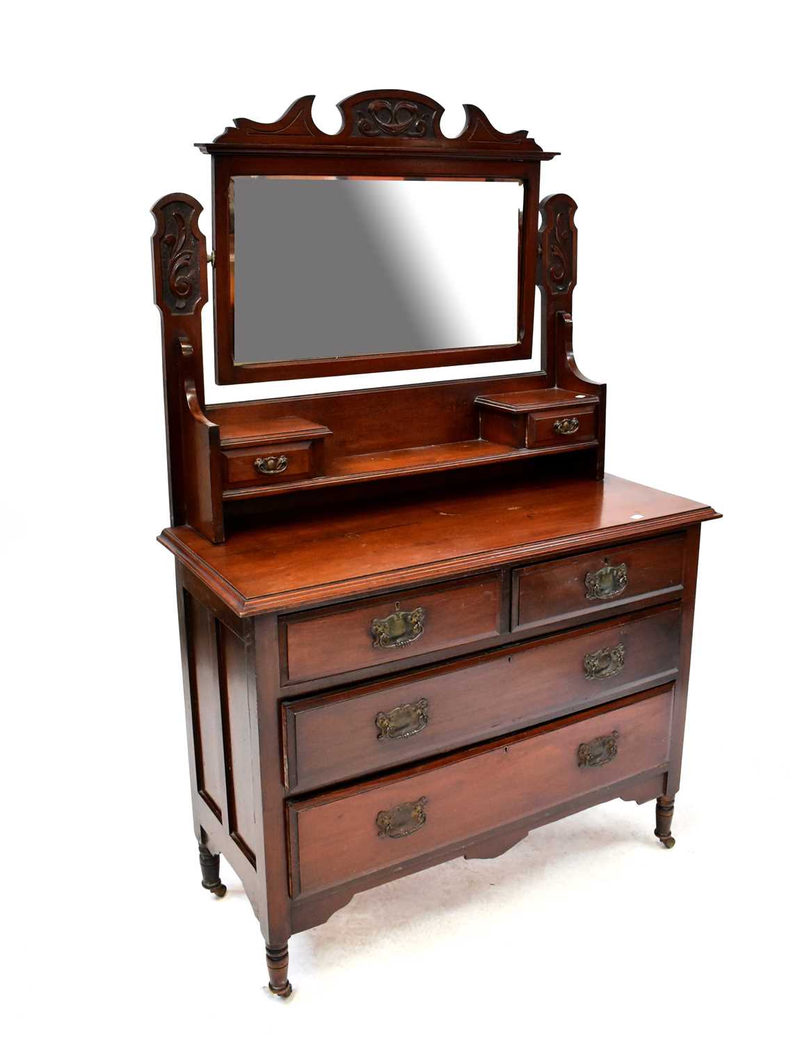 An early 20th century walnut dressing chest with bevelled mirror plate above two short jewellery