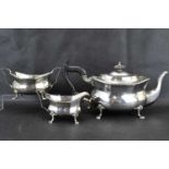 A George V hallmarked silver three-piece tea service with ebonised handle and knop, raised on four