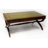 A large mahogany framed writing table with green leather inset panel to top and embossed floral