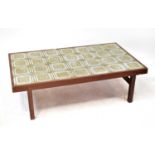 A vintage tile top coffee table within a teak frame, raised on square section supports, 42 x 146 x
