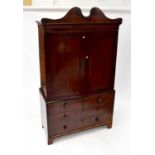 A Victorian mahogany linen press, the arched pediment with roundel decoration above a pair of