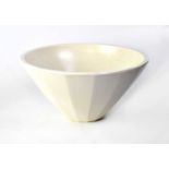 KEITH MURRAY FOR WEDGWOOD; a faceted bowl in cream, height 13cm, diameter 25.5cm.Condition Report: