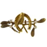 A 19th century 15ct gold brooch with small bird within horseshoe, flanked by seed pearls, length