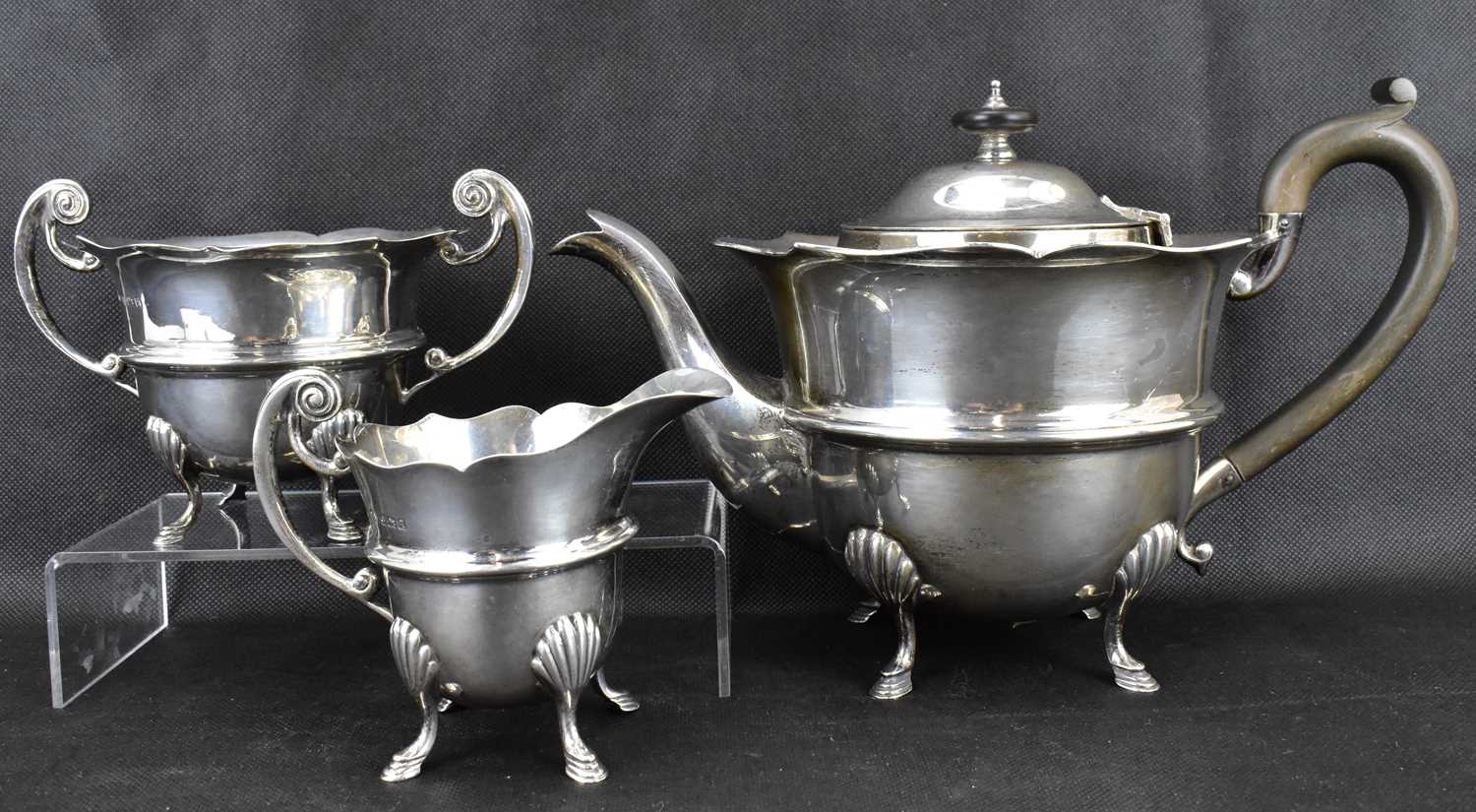 A George V hallmarked silver three-piece tea service with ebony-style handle and circular knop,