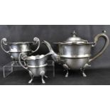 A George V hallmarked silver three-piece tea service with ebony-style handle and circular knop,