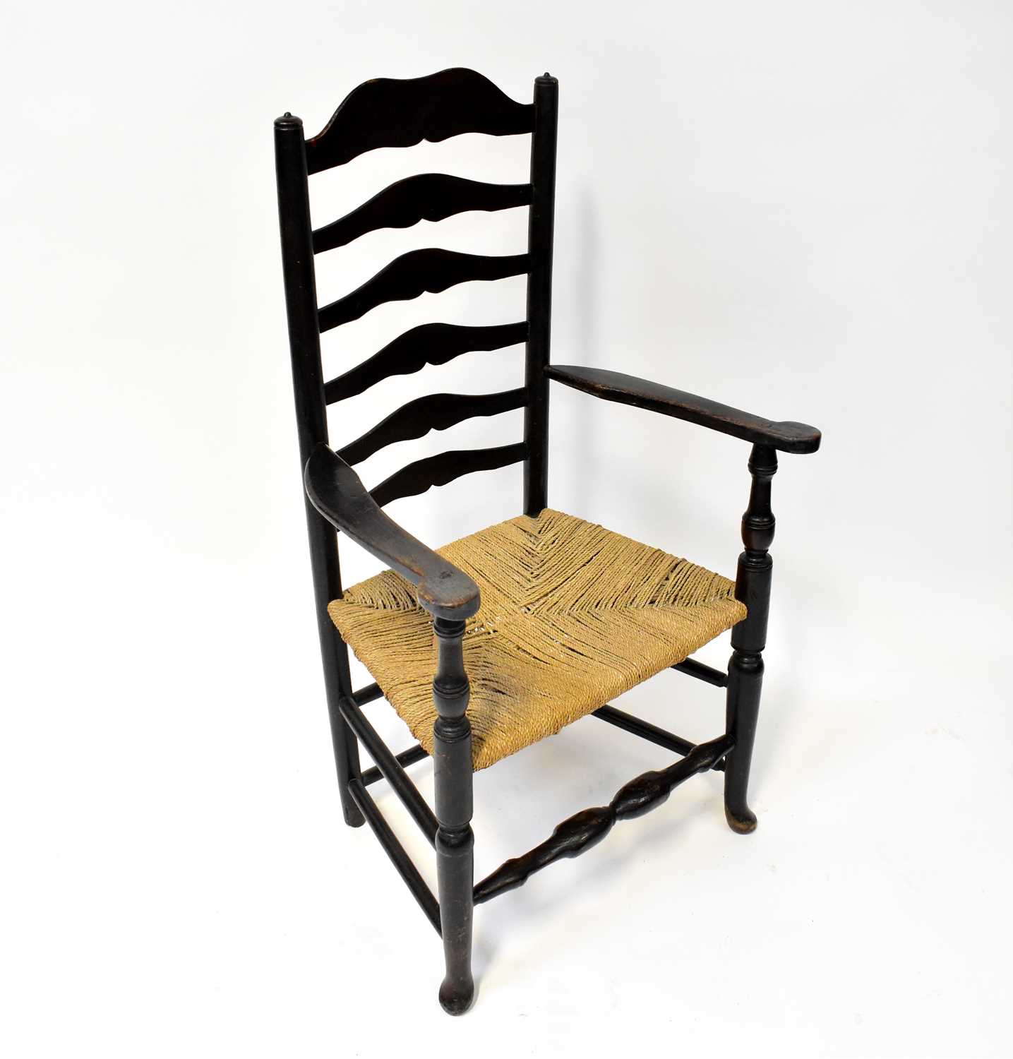 A 19th century ladder back armchair with rush seat.