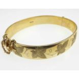 A 9ct gold hinged bracelet, half decorated in floral pattern, box clasp and safety chain, internal