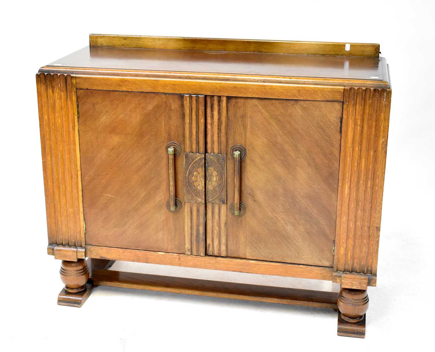 An early 20th century oak sideboard of Art Deco form, twin doors to ball supports, 94 x 121 x 46cm.