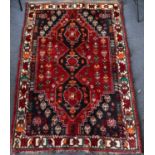 A Caucasus-style rug with three central guls within a diamond lozenge and a floral border, within