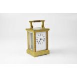 A brass cased carriage clock, the enamelled dial set with Roman numerals, with swing handle,