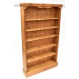A large pair of contemporary free-standing pine bookcases with five fixed shelves to plinth base,