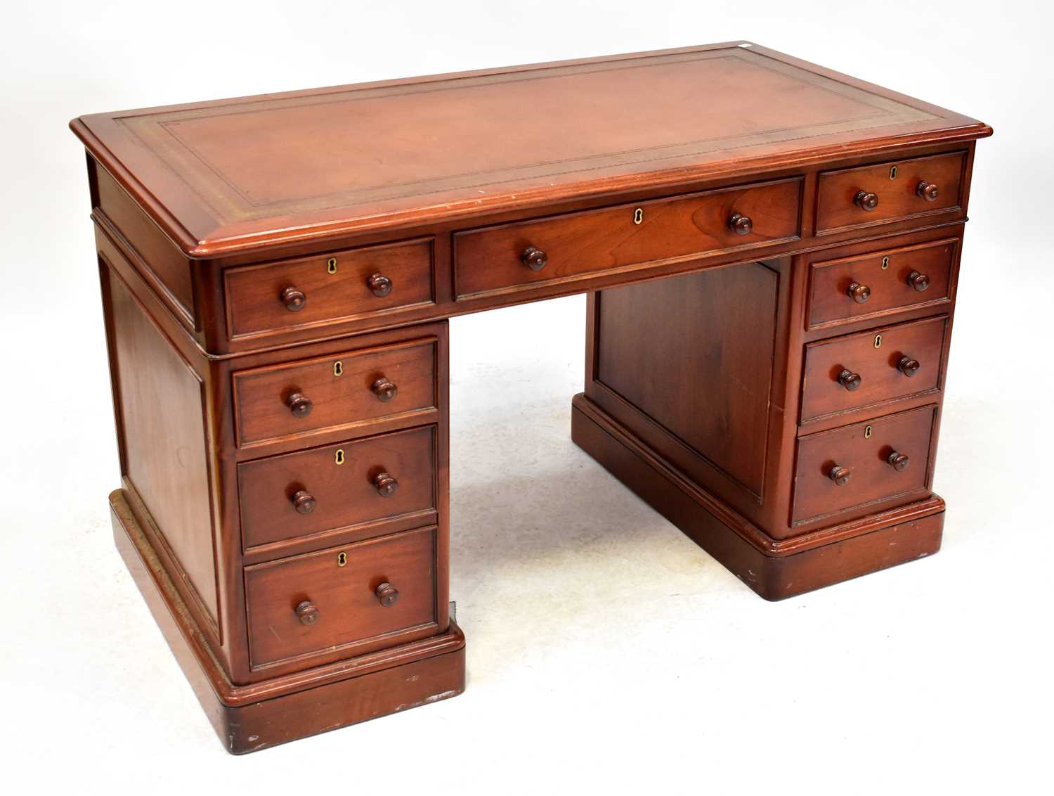 A reproduction mahogany nine-drawer twin pedestal desk with gilt tooled tan leather inset top, 77