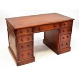 A reproduction mahogany nine-drawer twin pedestal desk with gilt tooled tan leather inset top, 77