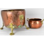 A large brass and copper coal bucket of oval shape, with lion mask and hoop handles, raised on