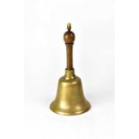 A brass school bell with turned wooden handle, height 34cm.