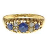 An 18ct gold diamond and sapphire ring, the central diamond flanked by two tiny diamonds, flanked by