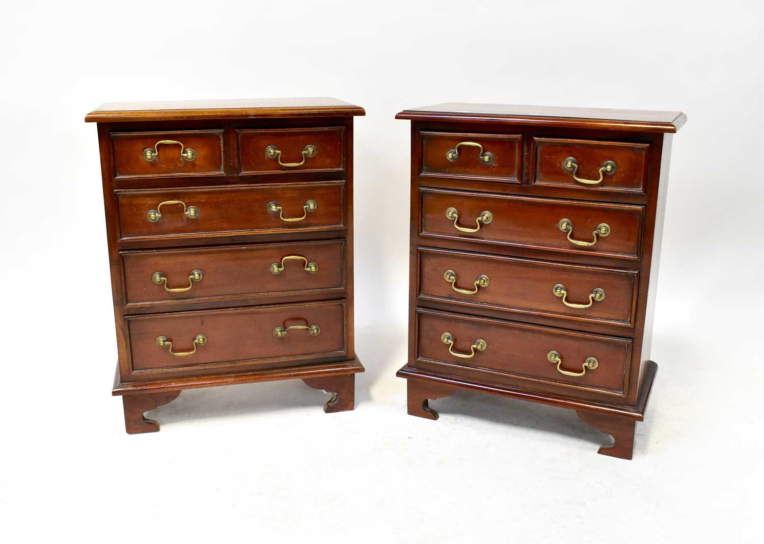 A pair of small mahogany chests of drawers of small proportions, with two short over three long