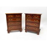 A pair of small mahogany chests of drawers of small proportions, with two short over three long