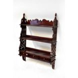 A reproduction mahogany wall shelf with pierced side supports and three base drawers, 92 x 66 x