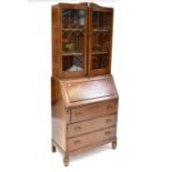 An early 20th century oak bureau bookcase with pair of leaded glass doors with two interior shelves,