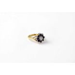 An 18ct gold cluster ring set with sapphire and diamonds, stamped 18, size J1/2, approx. 5.4g.