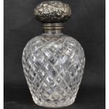 An Edwardian cut glass cologne decanter with hallmarked silver floral lid, and cut glass stopper,
