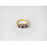 An 18ct gold ring set with three clusters of rubies within diamonds, stamped 750, size L, approx.