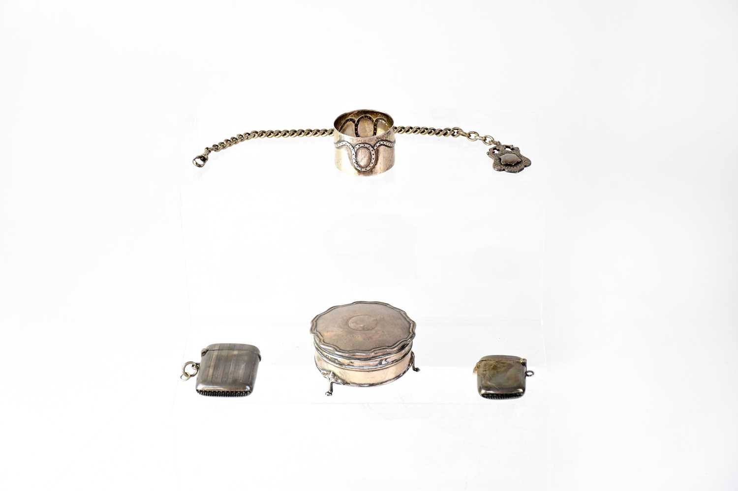 Silver items comprising a lidded jewellery box, two vesta cases, a watch chain with fob, and an