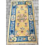 A 20th century Chinese rug with central apple blossom surrounded with vases of flowers and blossom