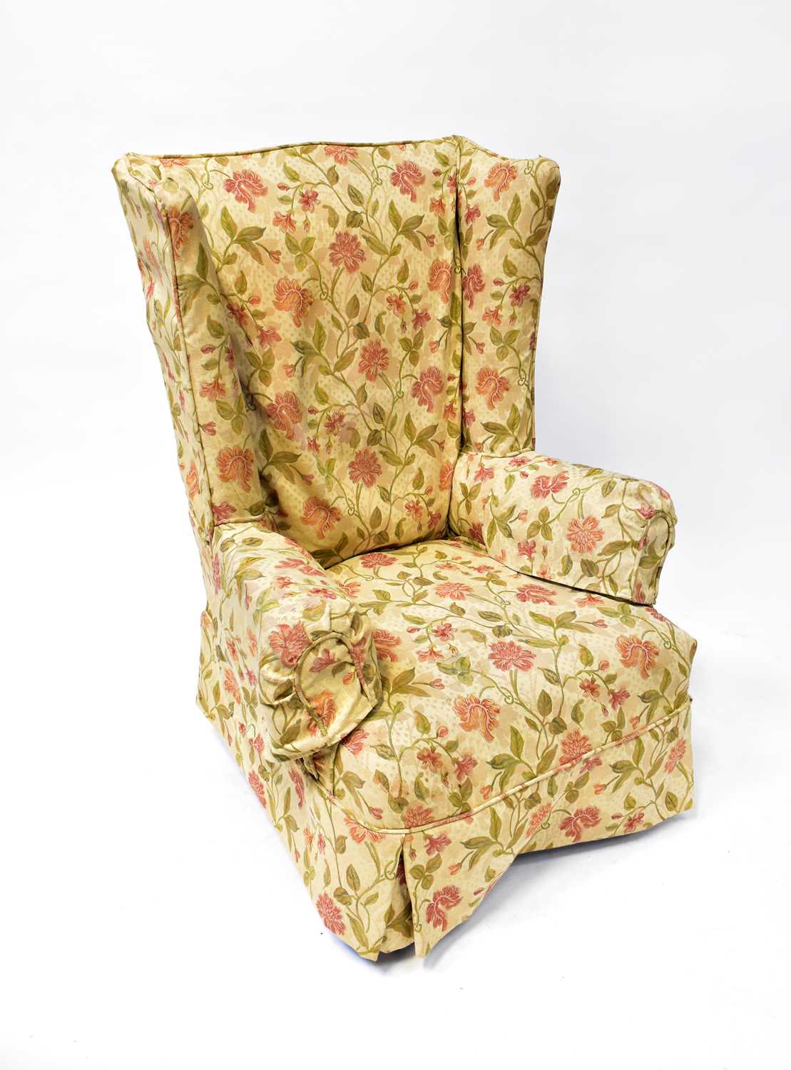 An early 20th century wing back armchair with floral upholstery, raised on cabriole legs to pad