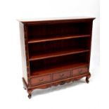 A reproduction mahogany open bookcase with two adjustable shelves above a base of three drawers