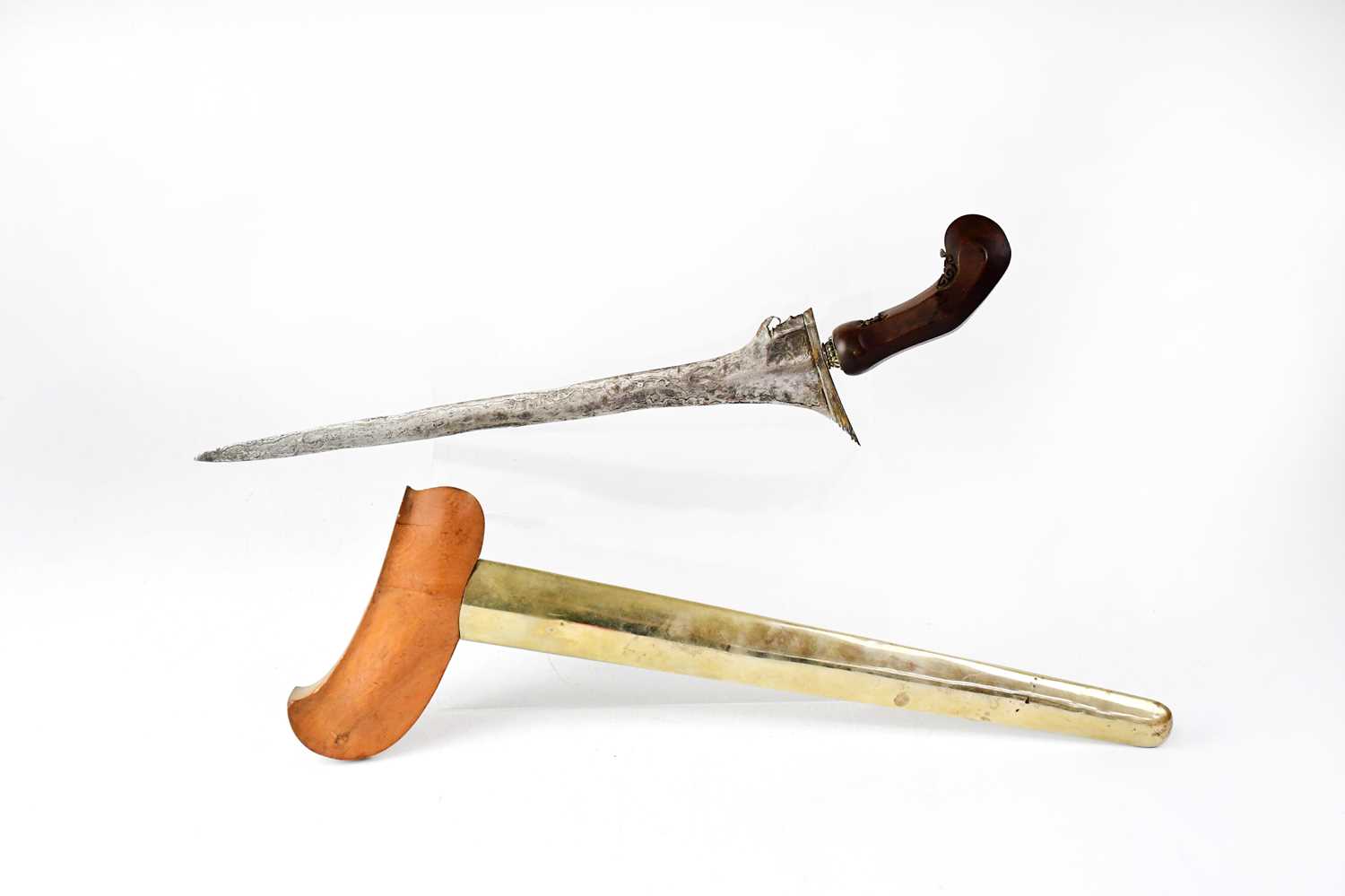 A late 18th/early 19th century Eastern Kris with carved shaped wooden handle and brass bound