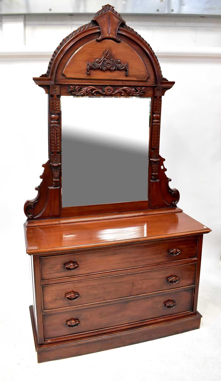 A large reproduction mahogany dressing chest, the arched pediment with gadrooned edge above bevelled