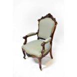 A Victorian walnut open arm parlour chair with carved foliate top, with overstuffed back, arms and