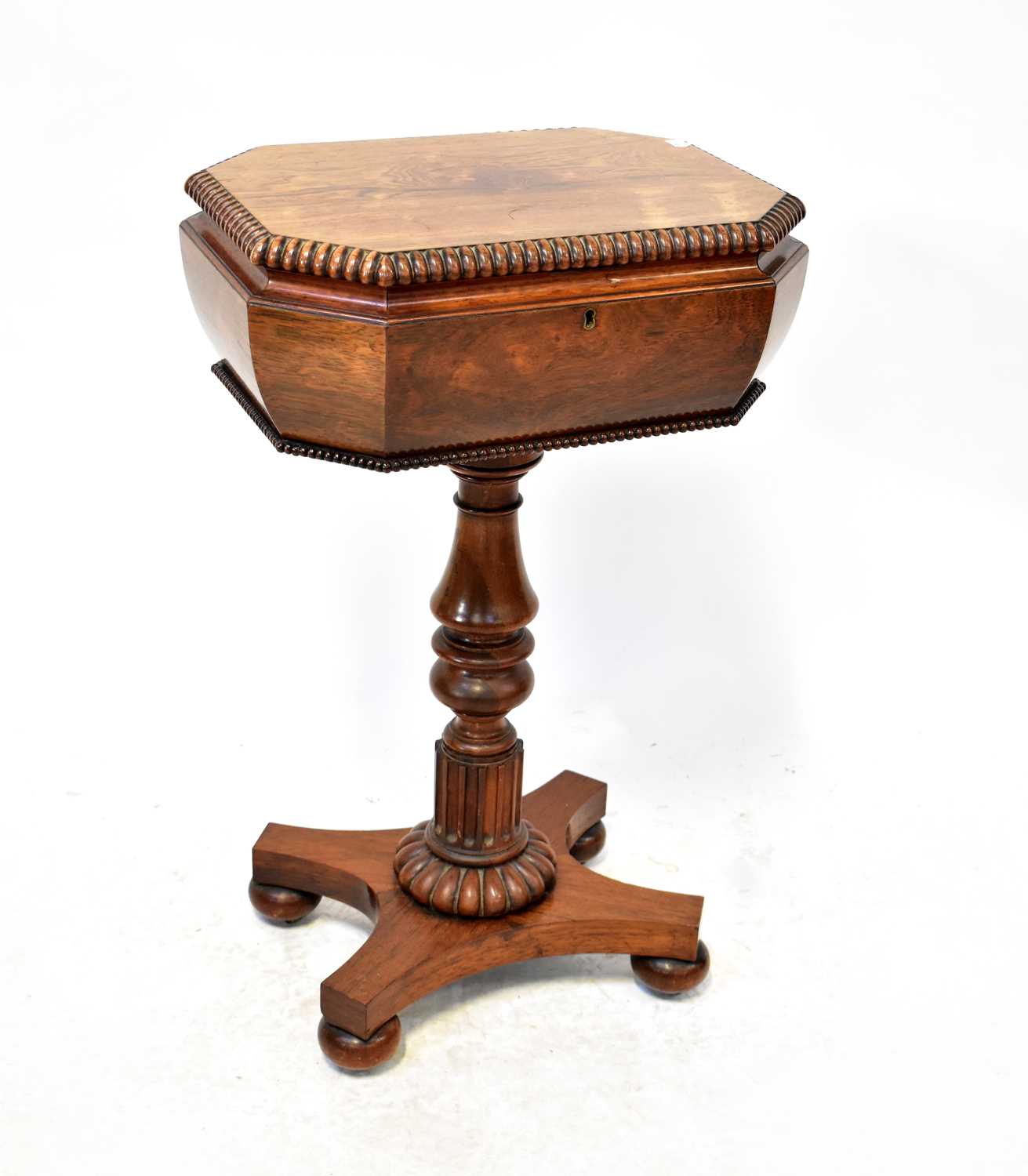 A Victorian rosewood teapoy, the rectangular top with canted corners and gadrooned rim, with