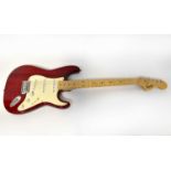 SQUIER; a red Stratocaster electric guitar (missing tremolo arm).