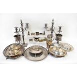 A quantity of silver plated ware to include a pair of three-branch candelabra, covered tureens,