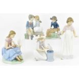 NAO; four porcelain figures comprising boy and girl on bench, girl with doves, girl with swan and